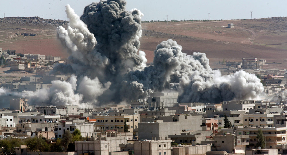 In this Monday, Nov. 17, 2014 file photo, smoke rises from the Syrian city of Kobani, following an airstrike by the U.S.-led coalition, seen from a hilltop outside Suruc, on the Turkey-Syria border.